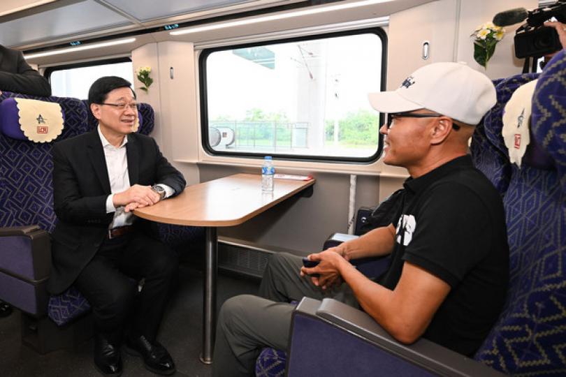 鐵路運作: 李家超（左）到訪中國老撾鐵路萬象火車站，在車廂與乘客交談。