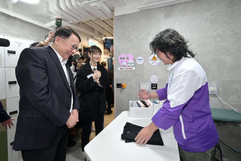 便利起居:  陳國基（左一）參觀筲箕灣社區客廳的洗衣設施。