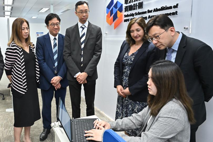 支援措施:  勞工及福利局局長孫玉菡（右二）觀看職員示範僱主如何透過一站式網上平台申請「取消強積金對沖安排資助計劃」資助。