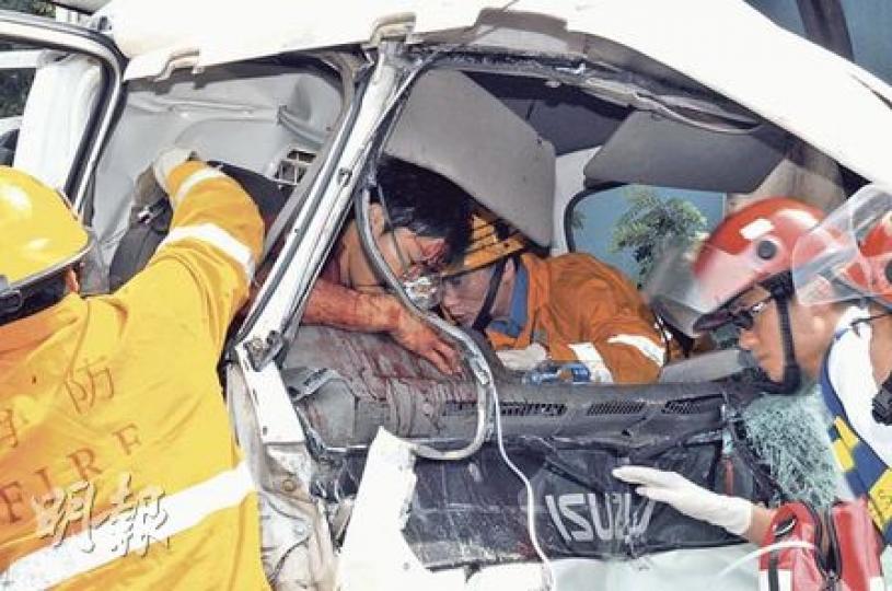 龍翔道近荷里活廣場對出的3車串燒車禍，運魚車車頭撞扁，司機被緊夾，消防拯救時他血流披面，狀甚痛苦。（馮國良攝）