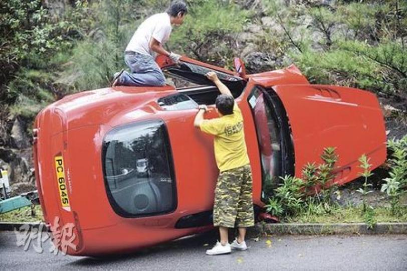 瑪沙拉蒂跑車在火炭穗禾路撞山後翻側，車頭嚴重損毁，拖車工人事後到場將之拖走維修。（何家達攝）