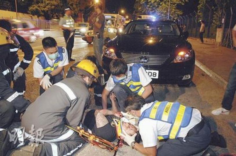 車禍中，一名被拋出車外的男子頭部重創，後腦鮮血直流，救護員即場搶救。（胡永輝攝）