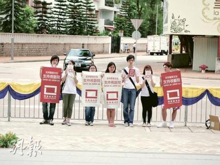 視藝學院學生昨日趁校長及校董會成員出席開幕禮，在會場外舉起「支持視藝院獨立」橫額無聲示威，反對傳理及視藝學院合併。（彭美芳攝）