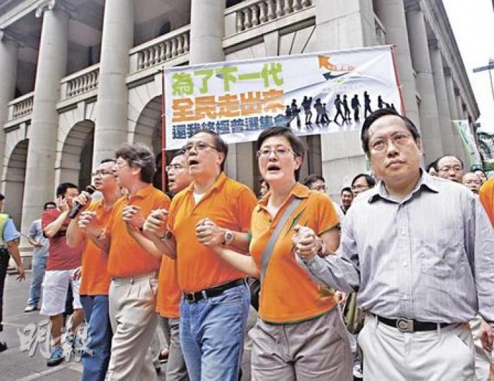 民主黨何俊仁（右起）、普選聯副召集人黃碧雲、民主黨楊森、普選聯召集人馮偉華、公民黨湯家驊、普選聯副召集人蔡耀昌，昨日在遮打花園集會被激進泛民支持者「馬拉松式」批評「出賣港人」近1小時，終重拾力氣，一起手牽手遊行至政府總部，要求「還我終極普選，取消功能組別」。（李紹昌攝）