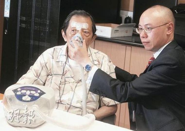 聯合醫院朱頌明醫生（右）示範協助慢阻肺病患者徐伯（左）使用「無創呼吸機」，朱醫生表示，該機器令病患氣管膨脹，令呼吸更加暢順，降低復發率。（劉焌陶攝）
