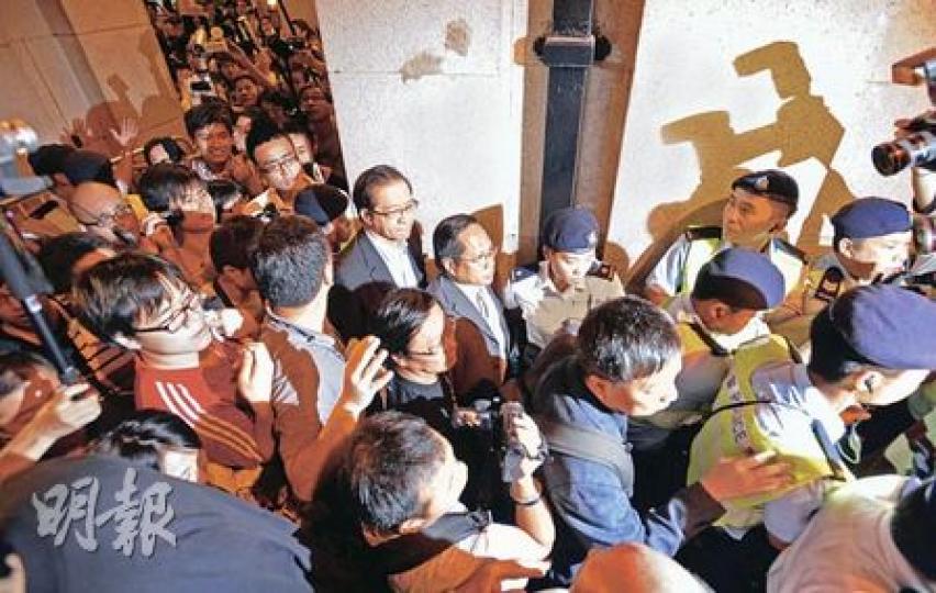 民主黨主席何俊仁（後排中）及一眾民主黨議員離開立法會時，刻意步出面向示威者集會的出口，結果引來示威者追罵，更有人向他潑水。社民連黃毓民其後刻意急步走到何俊仁的右邊身旁，伴他登車。（余俊亮攝）