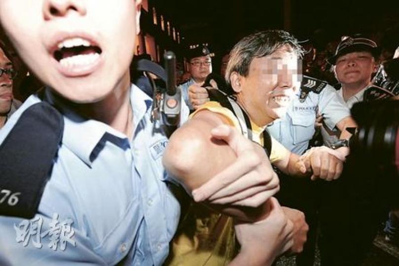 一名52歲楊姓男子（中）涉嫌在立法會外襲擊他人，被警方拘捕。事件中聲稱受傷的83歲和46歲的男子其後送院醫治。（何家達攝）