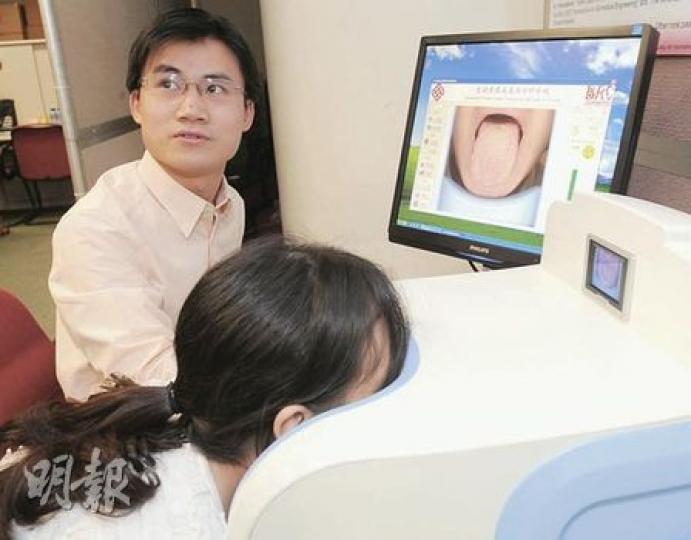 運用「電腦舌象採集與分析系統」，病人只需對着機器伸出舌頭，10多秒便能有診斷結果。（劉焌陶攝）