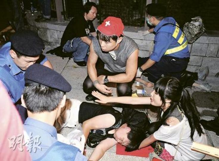 逾200名示威者在七一遊行後聚集政府總部，警方昨凌晨清場，「星屑醫生」歐陽英傑（戴帽者）自組社運醫療小隊協助，事後他在網誌撰文批評警方清場時使用過度暴力。（蔡方山攝）