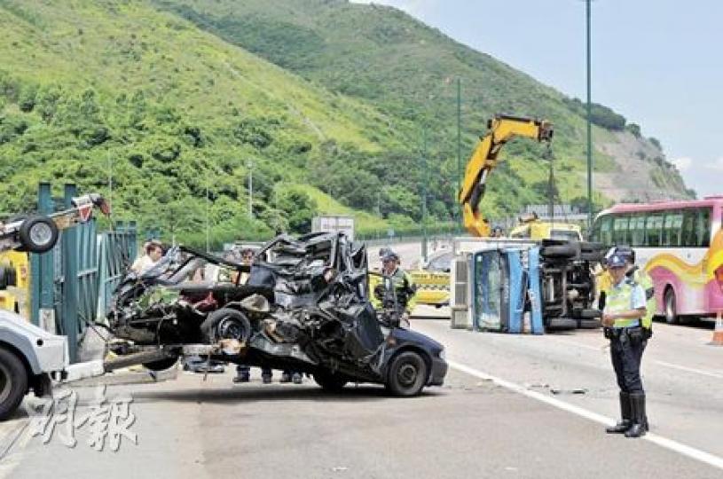 「拋錨」私家車被凍櫃貨車狂撼車尾，半截車身撞成廢鐵，貨車再滑行25米後翻側。私家車事後被拖走檢驗。（馮國良攝）