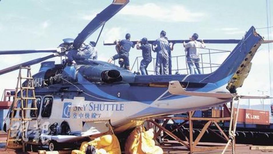 失事直升機由重型拖架車運到赤鱲角機場飛機庫，機頂螺旋槳已全被拆下，以免影響交通安全。（李銘攝）