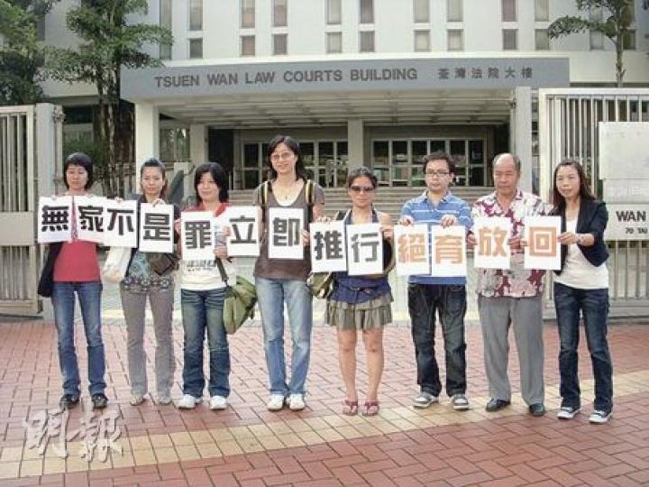 審訊後，被告陳任君（右一）與其他動物義工在庭外舉起標語，促漁護署將流浪貓狗絕育後再放回社區生活，不要動輒將貓狗人道毁滅。（梁珮珊攝）
