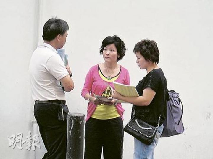 深培中學昨安排教師(左)在呂祺教育服務中心門外,向剛在中心領取註冊證的家長(中和右)派發傳單,講解學校各項支援新生的措施及資助。(陳嘉婉攝) 深培中學昨安排教師(左)在呂祺教育服務中心門外,向剛在中心領取註冊證的家長(中和右)派發傳單,講解學校各項支援新生的措施及資助。(陳嘉婉攝)