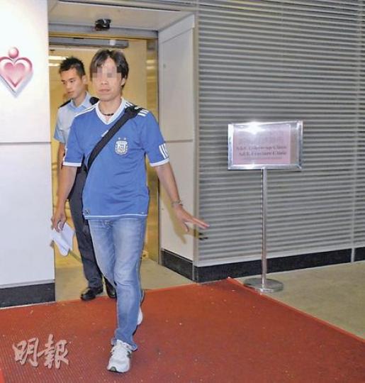 涉嫌襲警被捕的旅遊巴司機報稱不適，由警員陪同送院後再押返警署繼續調查。（劉友光攝）