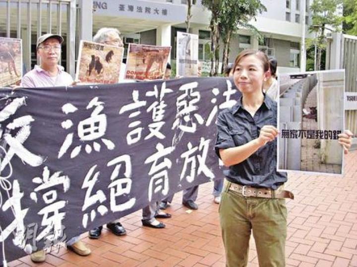 被判罰款的陳任君（右）昨在庭外與其他動物義工拉起橫額，並叫口號「反漁護惡法，要救不要殺」、「無家不是我的錯，不要殺死我」。（梁珮珊攝）