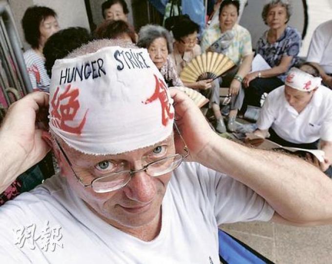 甘浩望神父(左)身後的一批家長已爭取她們的超齡子女來港逾11年,「甘仔」直言他們不能再等。(李紹昌攝) 甘浩望神父(左)身後的一批家長已爭取她們的超齡子女來港逾11年,「甘仔」直言他們不能再等。(李紹昌攝)
