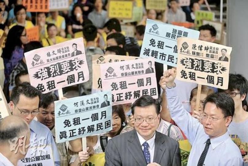 房委會資助房屋小組委員會昨決定公屋加租4.68%,但可在9月免租一個月。圖為多名居民團體向小組委員會主席張炳良(中)請願,促免租一個月。(朱永倫攝) 房委會資助房屋小組委員會昨決定公屋加租4.68%,但可在9月免租一個月。圖為多名居民團體向小組委員會主席張炳良(中)請願,促免租一個月。(朱永倫攝)