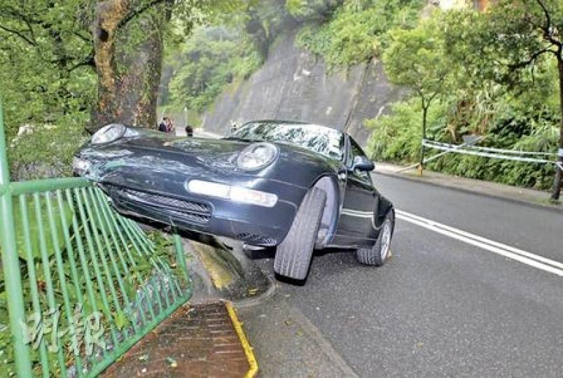 在山頂道失事的保持捷跑車先撞倒馬路一個路牌，打轉越過對面線後車頭剷上鐵欄，幸未衝出路面。（劉友光攝）失事保時捷司機Dario Dell'Antonio為西班牙國際銀行香港分行的董事總經理。（屈俊樂攝）