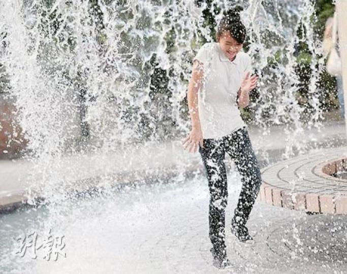 本港昨日市區氣溫高達33.4℃,有市民為消暑索性走入「瀑布」中。(朱永倫攝) 本港昨日市區氣溫高達33.4℃,有市民為消暑索性走入「瀑布」中。(朱永倫攝)