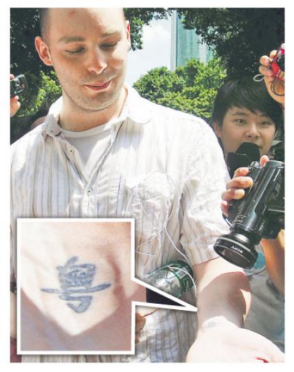 加拿大籍留學生向眾人展示其手腕上的「粵」字紋身(見小圖)。(明報記者攝) 加拿大籍留學生向眾人展示其手腕上的「粵」字紋身(見小圖)。(明報記者攝)