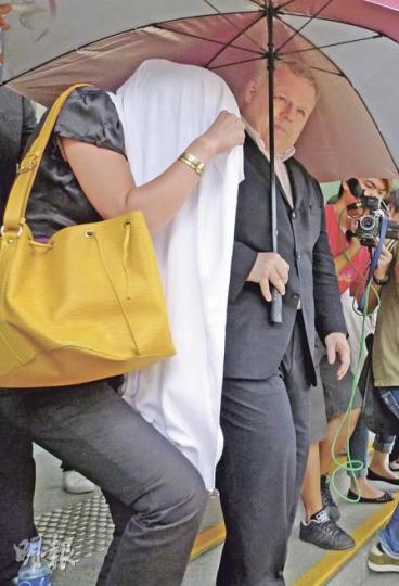 終院常任法官包致金的侄女Amina Mariam Bokhary(白布蒙頭者)免受牢刑,離開法院時安排4名男子護航,並撐起兩把大傘開路,一度與近30名傳媒推撞,場面混亂。(何偉畧攝)
終院常任法官包致金的侄女Amina Mariam Bokhary(白布蒙頭者)免受牢刑,離開法院時安排4名男子護航,並撐起兩把大傘開路,一度與近30名傳媒推撞,場面混亂。(何偉畧攝)