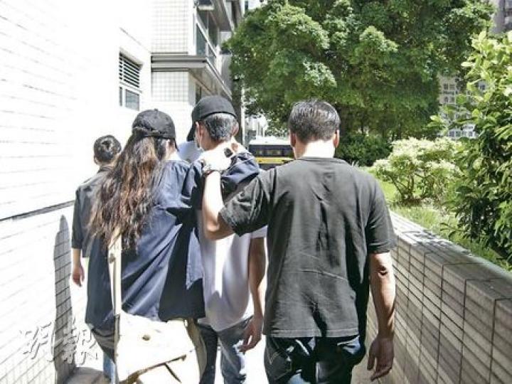 中四男生(右二)獲准保釋候審,在親友掩護下離開法庭。(梁珮珊攝) 中四男生(右二)獲准保釋候審,在親友掩護下離開法庭。(梁珮珊攝)