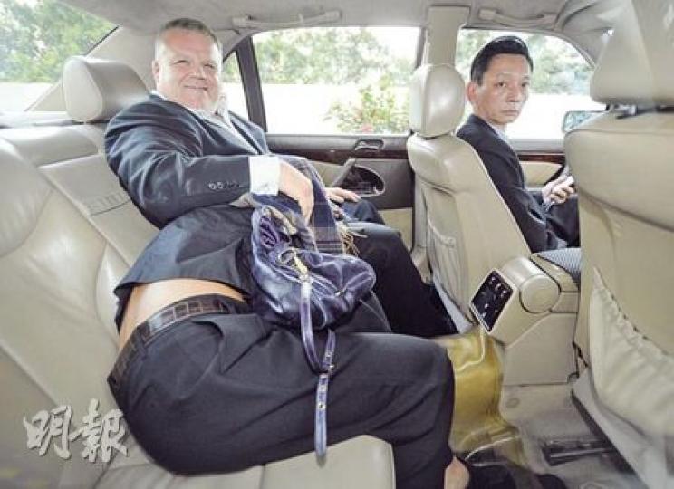 包致金侄女Amina由外籍保鑣護送,俯身慢行狼狽離庭。上車後,她俯伏保鑣大腿位置,保鑣則向記者面露笑容。(余俊亮攝) 包致金侄女Amina由外籍保鑣護送,俯身慢行狼狽離庭。上車後,她俯伏保鑣大腿位置,保鑣則向記者面露笑容。(余俊亮攝)
