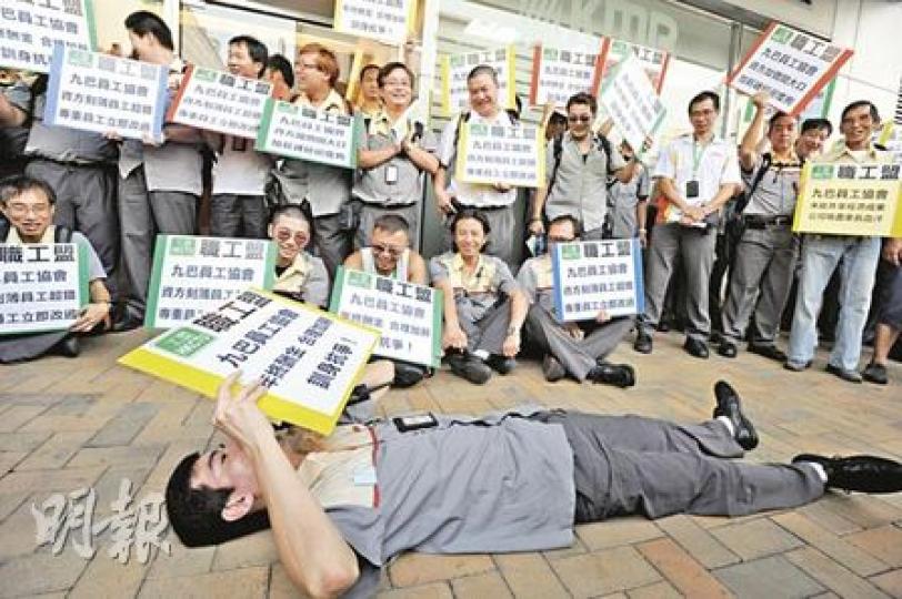 數十名九巴司機昨於荔枝角總部外請願,其中一名司機更一度橫臥地上帶頭叫口號,宣示「瞓身抗爭」。(尹錦恩攝) 數十名九巴司機昨於荔枝角總部外請願,其中一名司機更一度橫臥地上帶頭叫口號,宣示「瞓身抗爭」。(尹錦恩攝)