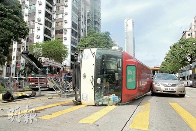 滿載乘客的小巴撞向石壆鐵欄及交通燈後翻側,車頂撞及旁邊私家車,差點把私家車壓着,私家車司機大呼好彩。(何朝財攝) 滿載乘客的小巴撞向石壆鐵欄及交通燈後翻側,車頂撞及旁邊私家車,差點把私家車壓着,私家車司機大呼好彩。(何朝財攝)
