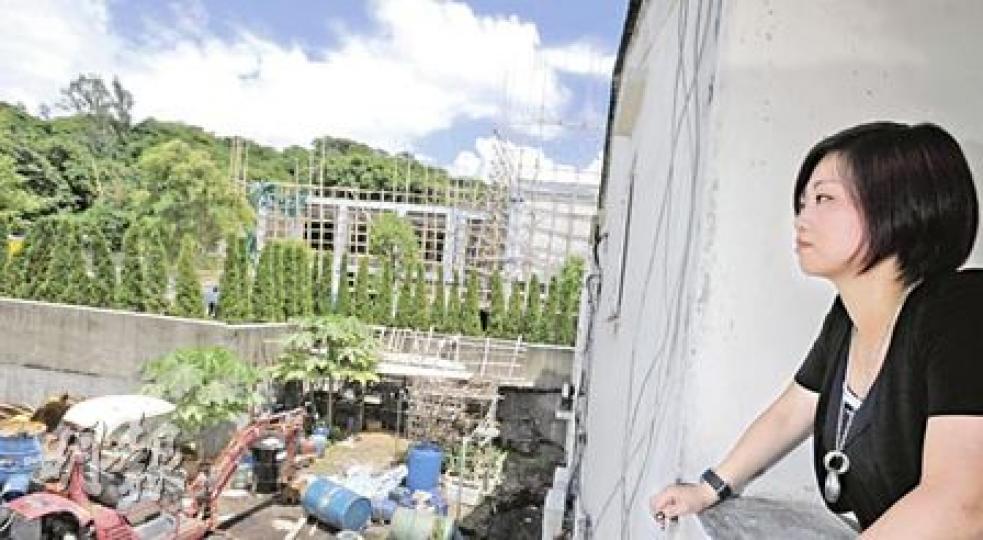 元朗新圍村村民郭太從窗外俯視旁邊的骨灰龕場工地,對與陰宅為鄰感到不安,並指該處施工時帶來噪音非常滋擾。(余俊亮攝) 元朗新圍村村民郭太從窗外俯視旁邊的骨灰龕場工地,對與陰宅為鄰感到不安,並指該處施工時帶來噪音非常滋擾。(余俊亮攝)