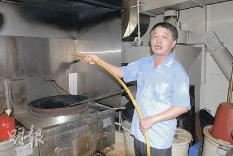製藥師傅游先生炒中藥「炒出火」,連爐灶部分地方亦被熏黑,他急忙取來水喉射水撲熄煙火。(劉友光攝) 製藥師傅游先生炒中藥「炒出火」,連爐灶部分地方亦被熏黑,他急忙取來水喉射水撲熄煙火。(劉友光攝)