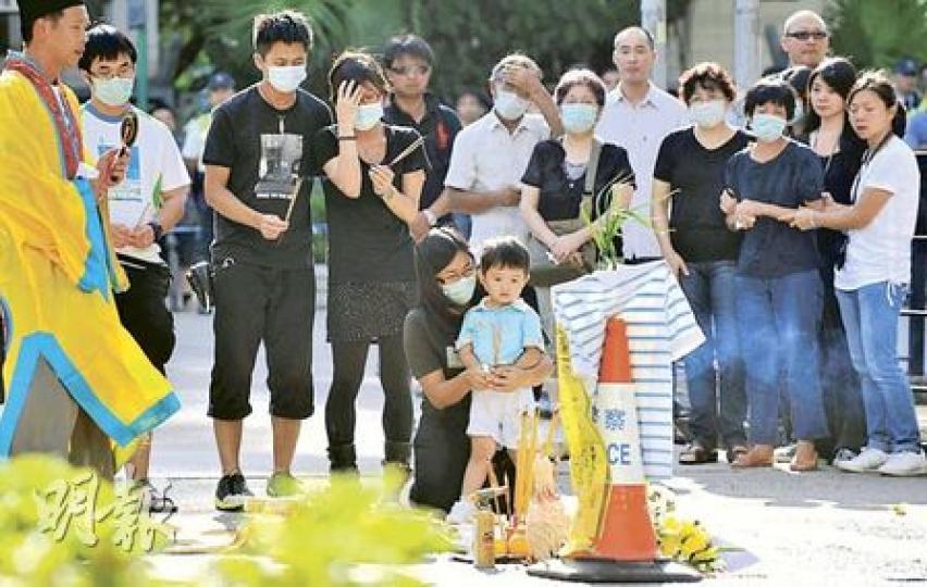 梁鼎崙的妻子（跪地者）及十多名親友到意外現場拜祭時傷心痛哭，兩歲兒子似乎不懂喪父之痛，上香祭父時一臉茫然。（余俊亮攝）