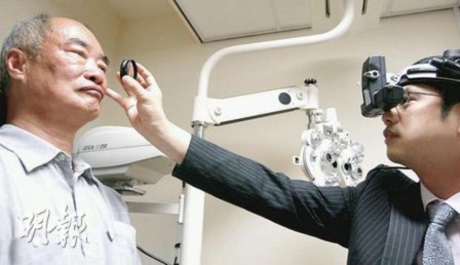 60多歲的陳伯伯（左）昨日在理大眼科視光學診所，示範接受眼科視光師徐芸生（右）的度數檢測。（郭慶輝攝）