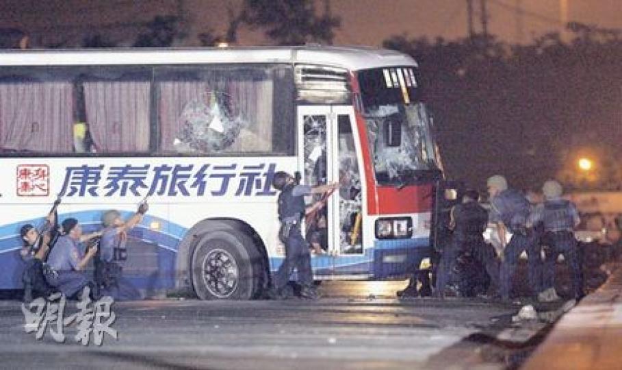 菲律賓特種部隊用大鐵槌擊打旅遊巴大門玻璃,但擊打多次也只能令大門玻璃碎裂,即使加上腳踢,始終仍然未能打開車門。有警員在槍林彈雨中連頭盔都沒有。(林振東攝) 菲律賓特種部隊用大鐵槌擊打旅遊巴大門玻璃,但擊打多次也只能令大門玻璃碎裂,即使加上腳踢,始終仍然未能打開車門。有警員在槍林彈雨中連頭盔都沒有。(林振東攝)