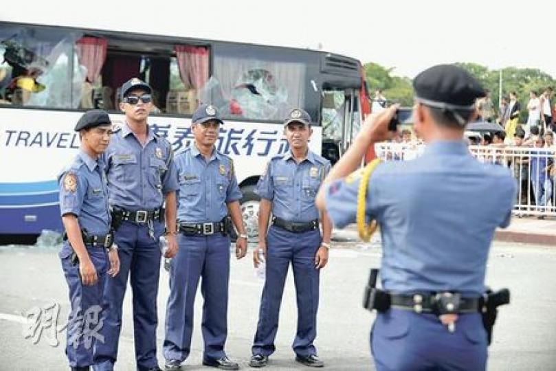 菲律賓警察在前日處理挾持事件時被轟失當無能,當地警察部亦承認營救時犯下多宗錯誤,但言猶在耳,昨日卻有警員在肇事的旅遊巴前拍照留念。(葉漢華攝) 菲律賓警察在前日處理挾持事件時被轟失當無能,當地警察部亦承認營救時犯下多宗錯誤,但言猶在耳,昨日卻有警員在肇事的旅遊巴前拍照留念。(葉漢華攝)