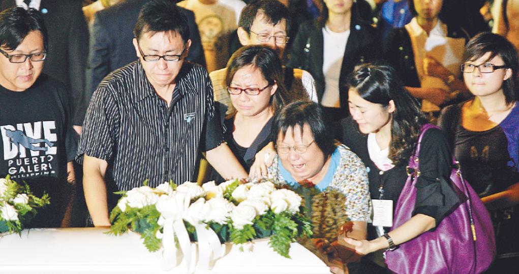 在挾持事件中殉職的旅行團領隊謝廷駿遺體昨晚運返香港。看着靈柩,謝廷駿的父母和兄弟傷心流淚,謝母更一度伏在棺木失聲痛哭。(郭慶輝攝)臂纏黑紗的傅太曾懿麗,抱起4歲女兒頌賢與兒子澤賢,向爸爸傅卓仁的棺木送上家書。他們身邊是政務司長唐英年,後排右起是中聯辦副主任李剛及外交部駐港特派員呂新華。(郭慶輝攝)在菲律賓遇害的8名康泰團友的靈柩,以及大部分倖存團友及家屬,昨晚由包機載返本港。政務司長唐英年、中聯辦副主任李剛、外交部駐港特派員呂新華及多名局長到場迎靈及慰問獻花。(郭慶輝攝)下顎中槍的易少玲昨晚乘醫 在挾持事件中殉職的旅行團領隊謝廷駿遺體昨晚運返香港。看着靈柩,謝廷駿的父母和兄弟傷心流淚,謝母更一度伏在棺木失聲痛哭。(郭慶輝攝)臂纏黑紗的傅太曾懿麗,抱起4歲女兒頌賢與兒子澤賢,向爸爸傅卓仁的棺木送上家書。他們身邊是政務司長唐英年,後排右起是中聯辦副主任李剛及外交部駐港特派員呂新華。(郭慶輝攝)在菲律賓遇害的8名康泰團友的靈柩,以及大部分倖存團友及家屬,昨晚由包機載返本港。政務司長唐英年、中聯辦副主任李剛、外交部駐港特派員呂新華及多名局長到場迎靈及慰問獻花。(郭慶輝攝)下顎中槍的易少玲昨晚乘醫