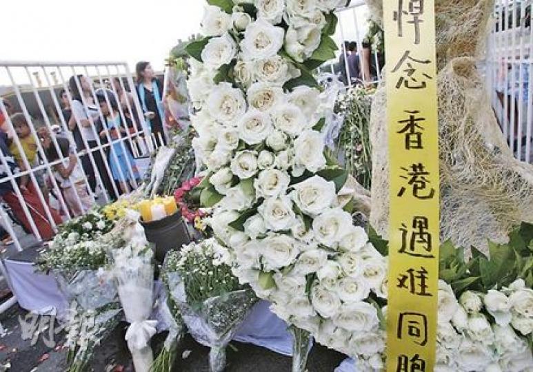 發生挾持事件的康泰旅遊巴昨日傍晚已被拖走,路中心則堆滿大批憑弔的花圈,「悼念香港遇難同胞」。(林振東攝) 發生挾持事件的康泰旅遊巴昨日傍晚已被拖走,路中心則堆滿大批憑弔的花圈,「悼念香港遇難同胞」。(林振東攝)