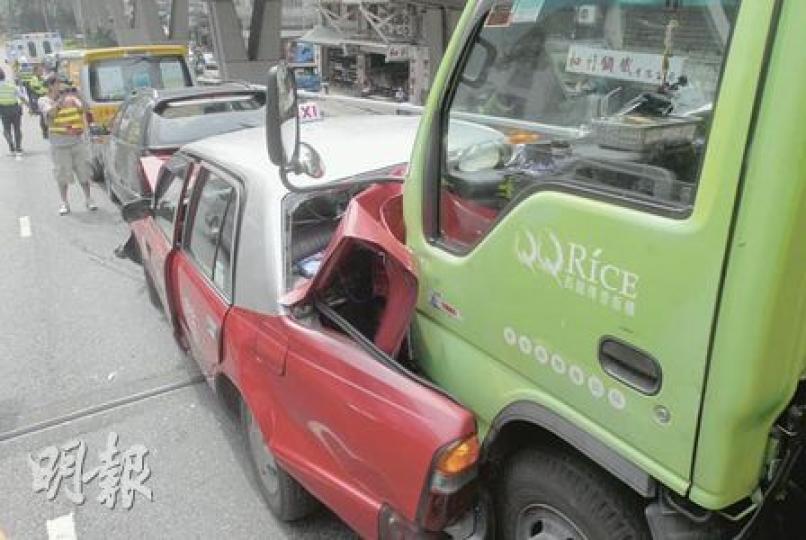 的士遭貨車猛撞車尾後嚴重摺曲,貨車車頭更陷入其車尾。(劉友光攝) 的士遭貨車猛撞車尾後嚴重摺曲,貨車車頭更陷入其車尾。(劉友光攝)