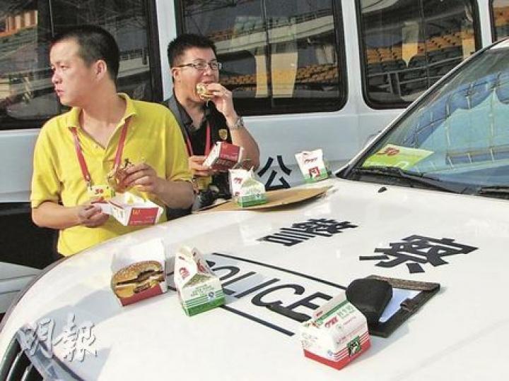 由於會場外沒有提供枱椅,準備進場採訪的記者唯有將警車充當桌子用早餐。(李泉攝) 由於會場外沒有提供枱椅,準備進場採訪的記者唯有將警車充當桌子用早餐。(李泉攝)