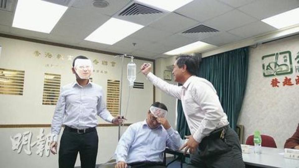 教聯會正聯絡教協和教評會等教師組織發起反殺校聯盟,昨在記者會上演話劇,有人戴上教育局長孫明揚面具(左一),諷刺孫明揚推出紓緩殺校的八招,對面臨殺校的中學只是「吊鹽水」,長遠難以解決殺校問題,希望刺破「鹽水袋」,要求教育局認真解決問題。(蕭輝浩攝) 教聯會正聯絡教協和教評會等教師組織發起反殺校聯盟,昨在記者會上演話劇,有人戴上教育局長孫明揚面具(左一),諷刺孫明揚推出紓緩殺校的八招,對面臨殺校的中學只是「吊鹽水」,長遠難以解決殺校問題,希望刺破「鹽水袋」,要求教育局認真解決問題。(蕭輝浩攝)