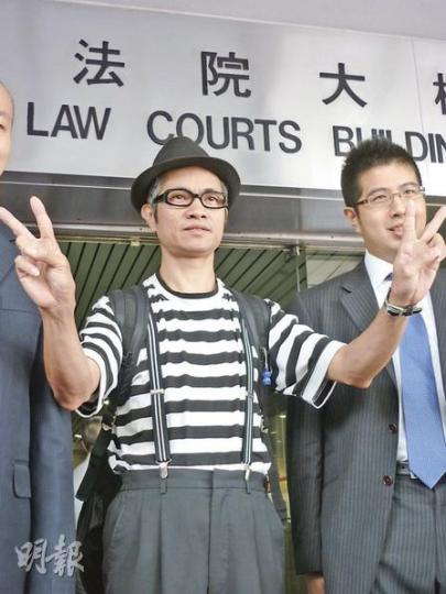 街頭藝人蘇春就(左)昨被裁定阻街罪名不成立後,在庭外高舉勝利手勢,右為其代表大律師、李柱銘兒子李祖詒。(利嘉茵攝) 街頭藝人蘇春就(左)昨被裁定阻街罪名不成立後,在庭外高舉勝利手勢,右為其代表大律師、李柱銘兒子李祖詒。(利嘉茵攝)