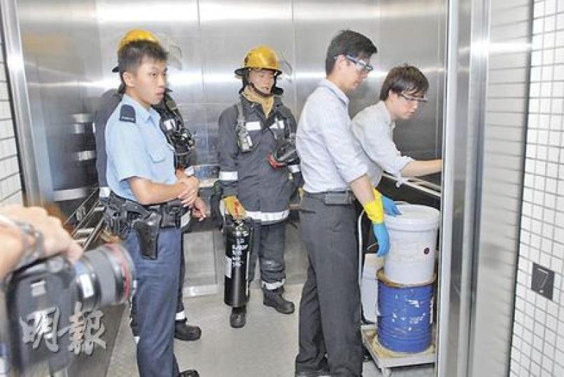 戴上保護眼罩的科大職員,在警員及消防員陪同下,將泄漏的化學品放入密封膠桶內運走處理。(蘇偉明攝) 戴上保護眼罩的科大職員,在警員及消防員陪同下,將泄漏的化學品放入密封膠桶內運走處理。(蘇偉明攝)