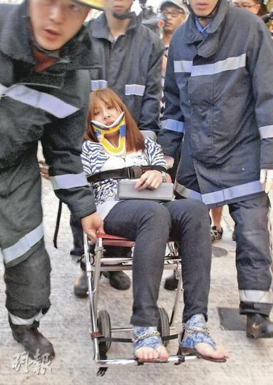 房車上一名女乘客受傷,送院時要戴上頸箍。(李銘攝)的士男乘客血流披面,包紮後由消防救出送院。(李銘攝) 房車上一名女乘客受傷,送院時要戴上頸箍。(李銘攝)的士男乘客血流披面,包紮後由消防救出送院。(李銘攝)