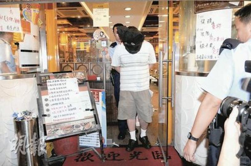 涉嫌懷刀闖入茶餐廳傷人的男子事後被警方蒙頭押走。(蔡方山攝) 涉嫌懷刀闖入茶餐廳傷人的男子事後被警方蒙頭押走。(蔡方山攝)