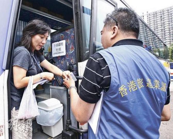 旅議會昨起一連3日於不同景點大規模抽查,由穿上背心的旅議會職員檢查導遊有否掛上有效證件及向旅客派發行程表等。(李紹昌攝) 旅議會昨起一連3日於不同景點大規模抽查,由穿上背心的旅議會職員檢查導遊有否掛上有效證件及向旅客派發行程表等。(李紹昌攝)