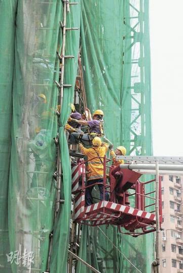 泥水女工在干德道殷榮閣棚架工作時,由4樓棚架墮下3樓工作台,腳部扭傷,要由消防員用升降台救下送院。(林錫禮攝) 泥水女工在干德道殷榮閣棚架工作時,由4樓棚架墮下3樓工作台,腳部扭傷,要由消防員用升降台救下送院。(林錫禮攝)