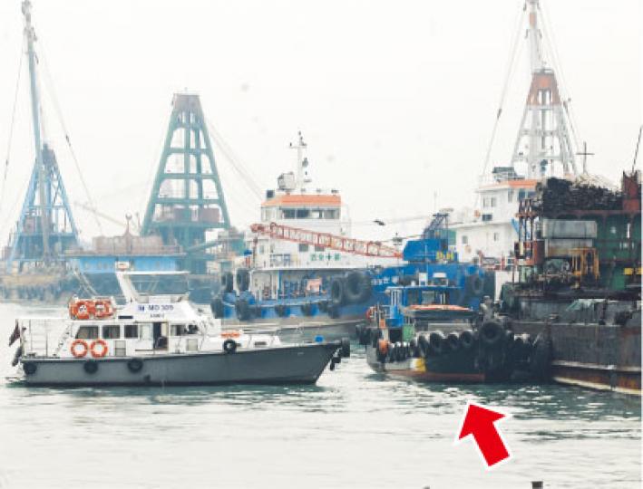 肇事駁艇(箭嘴示)事後停泊在油麻地避風塘一艘躉船旁,海事處船隻(左)駛近駁艇調查。(劉友光攝) 肇事駁艇(箭嘴示)事後停泊在油麻地避風塘一艘躉船旁,海事處船隻(左)駛近駁艇調查。(劉友光攝)