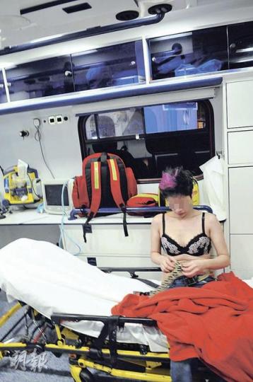 醉酒當街脫衣的女子事後被警方帶上救護車,但她仍未有即時穿回衣服,只顧整理皮帶等衣飾。(蔡方山攝) 醉酒當街脫衣的女子事後被警方帶上救護車,但她仍未有即時穿回衣服,只顧整理皮帶等衣飾。(蔡方山攝)