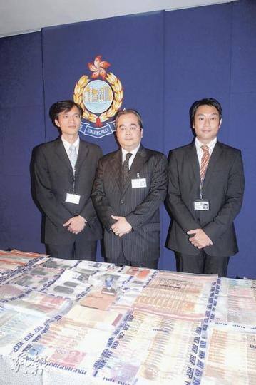 警方有組織罪案及三合會調查科警司鄭福全(中)展示行動中搜獲的大量現金,當中有港幣,亦有人民幣。(衛永康攝) 警方有組織罪案及三合會調查科警司鄭福全(中)展示行動中搜獲的大量現金,當中有港幣,亦有人民幣。(衛永康攝)