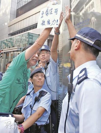 一批社運人士昨在警察總部外抗議,「女長毛」雷玉蓮(綠衣者)昨示威時高舉一袋豆腐,諷刺「豆腐沒有殺傷力」。(李紹昌攝) 一批社運人士昨在警察總部外抗議,「女長毛」雷玉蓮(綠衣者)昨示威時高舉一袋豆腐,諷刺「豆腐沒有殺傷力」。(李紹昌攝)